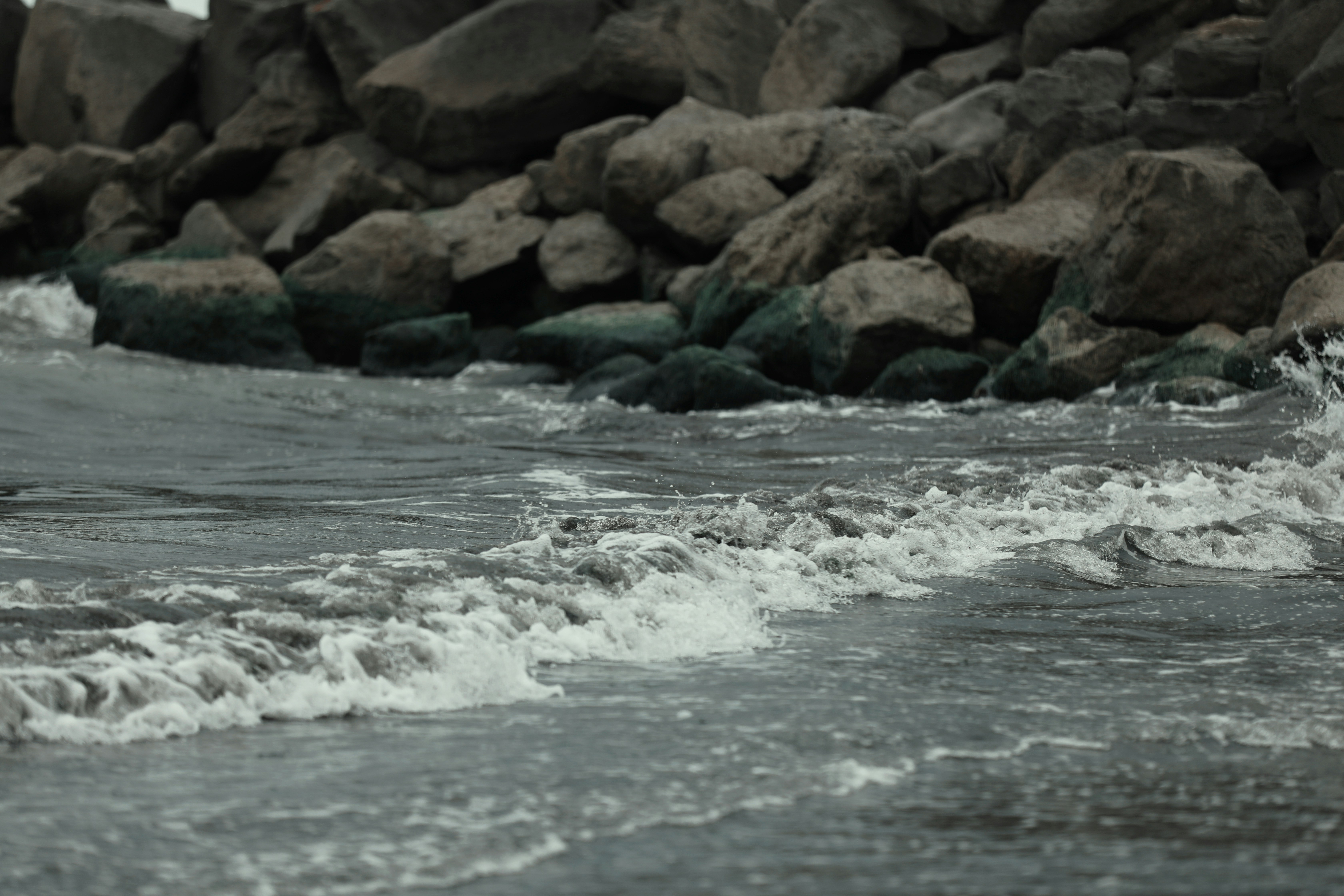 Waves crash against rocks on the shoreline.